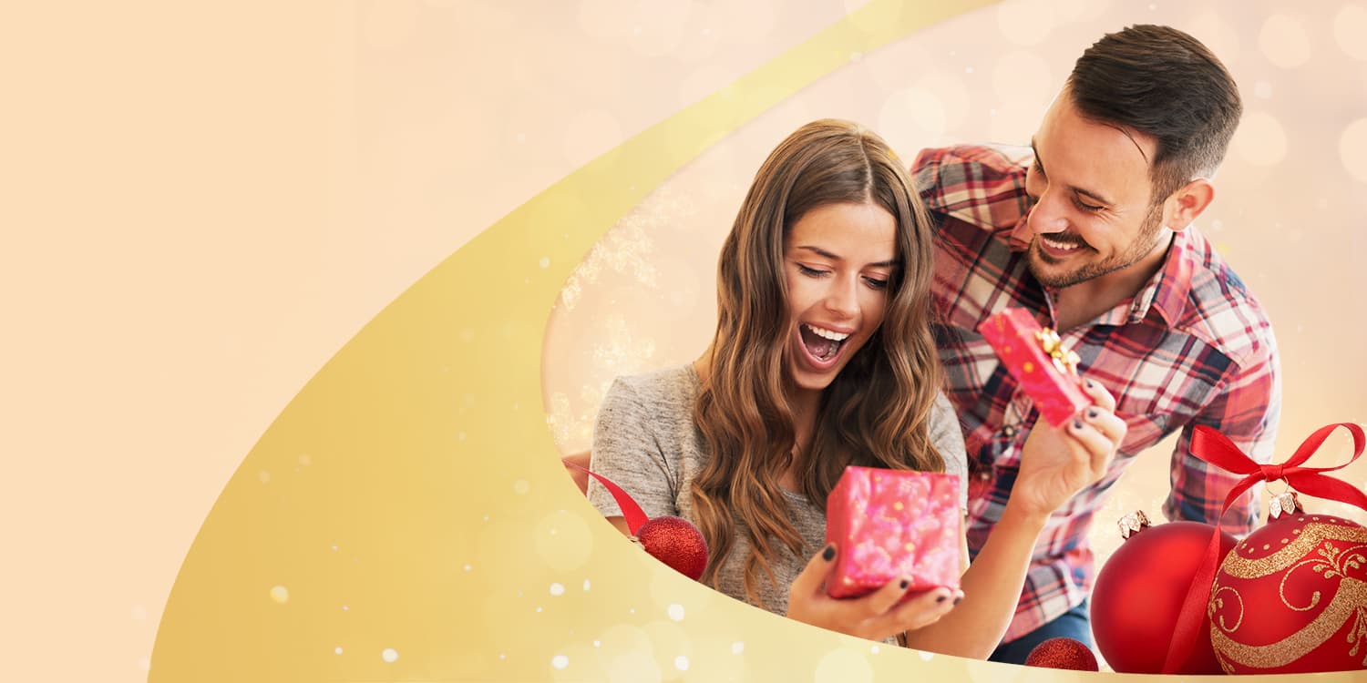 Giovane donna che apre un buono regalo per le lezioni di danza di Arthur Murray